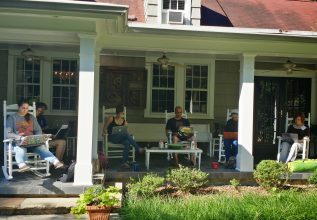 A group of students working on the porch of the reteat house